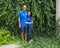 Middle-aged Caucasian man and his Korean wife standing in front of  a wall of dense Ivy in Bar Harbor, Maine.