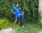 Middle-aged Caucasian man and his Korean wife standing in front of  a wall of dense Ivy in Bar Harbor, Maine.