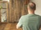 Middle-aged caucasian man practicing meditation, yoga near mirror with his reflection with wooden background with place for text