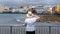 Middle aged Caucasian woman wearing a straw hat, looking towards the popular resort of El Medano, Tenerife, Canary Islands, Spain