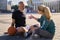 Middle aged couple, active man and woman in sportswear talking while relaxing after basketball workout outdoors on a