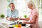 Middle Aged Couple Cooking Meal In Kitchen Together