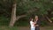 Middle-aged couple hugging near a beautiful tree.