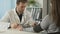 Middle-aged doctor checking female patient\'s blood pressure at hospital, clinic