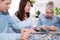 Middle-aged family elderly collects jigsaw puzzles at the table in the room