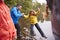 Middle aged father holding his daughterï¿½s hand while she balances on the shore of a lake, Lake District, UK