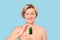 Middle aged female holding organic rejuvenation oil in glass bottle
