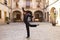 Middle-aged flamenco man with long hair dancing flamenco in a square with columns and balconies in seville, spain. Feel the