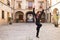 Middle-aged flamenco man with long hair dancing flamenco in a square with columns and balconies in seville, spain. Feel the