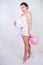 Middle-aged girl really wants to get pregnant. woman standing in pajamas with an air balloon under a t-shirt on a white background