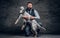 Middle-aged hunter dressed in elegant clothes sits on his knee and holding his purebred English Setter.