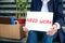 Middle-Aged and Jobless Close-up of Fired Worker Hands Holding Need work Banner