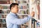 Middle Aged Korean Male Taking Book From Bookshelf In Library