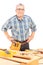 Middle aged male carpenter standing behind working table