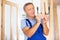 Middle-aged male locksmith examining a doorknob before installing it on a door in a house