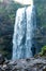 Middle aged male stood infront of Henrhyd Falls near Coelbren, the highest waterfall in South Wales, UK