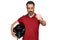 Middle aged man with beard holding motorcycle helmet annoyed and frustrated shouting with anger, yelling crazy with anger and hand