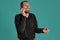 Middle-aged man with beard and mustache, wears black shirt, posing against a blue background. Sincere emotions concept.