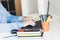 Middle aged man in blue shirt using laptop on modern stylish work place with office supplies, glasses, notebooks and books, desk