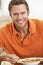 Middle Aged Man Eating Soup, Smiling At The Camera