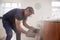 Middle aged man opening smoke filled oven in the kitchen