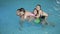 Middle-aged man plays in the pool with his three daughters. Happy weekend.