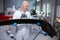 Middle-aged man in protective gloves prepares a car body part for painting