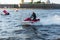 A middle-aged man rides a jet ski on the Neva River in the center of St. Petersburg. Warships on the background. Sunny day. Summer