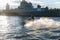 A middle-aged man rides a jet ski on the Neva River in the center of St. Petersburg. Warships on the background. Sunny day. Summer