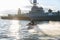 A middle-aged man rides a jet ski on the Neva River in the center of St. Petersburg. Warships on the background. Sunny day. Summer