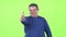 Middle aged man is showing a thumbs up. Green screen. Slow motion