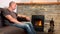 Middle-aged man sits near a hot burning fireplace and looks thoughtfully at the fire, concept of winter relaxation