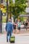 Middle aged man walking on a street with a wheeled bag. A man going with the suitcase in the city