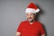 Middle aged man wearing santa hat and red t-shirt