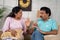 Middle aged married Indian couple arguing each other on sofa at home - concept of Disagreement, Spouse Confrontation and