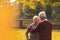 Middle aged married people standing in park fall medium shot copy space senior people support