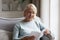 Middle-aged mature woman reading interesting book at home