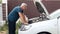 A middle-aged mechanic examines a malfunction in a car. Fixing the car yourself.