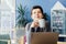 Middle aged minded pensive employee business woman in casual clothes holds coffee cup works at office desk with pc laptop.