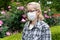 Middle aged mixed race blonde woman with eyeglasses wearing white surgical mask. Protection against Coronavirus COVID-19