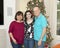 Middle-aged mother, elderly father and teenage daughter in front of a Christmas Tree