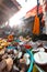 A middle-aged Nepali man sells various items for worship at a temple during sunrise in