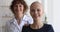 Middle-aged nurse standing behind cancer patient headshot portrait