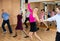 Middle-aged pair practicing ballroom dance in dance studio