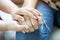 Middle-aged people sit indoors holding hands close up photo. Spouses feeling connection and love