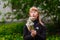 Middle-aged woman blowing off dandelion seeds outdoors