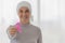 Middle-aged woman cancer patient lost hair from chemo cure process and use clothe cover her head holding pink ribbon the symbol of