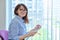 Middle aged woman with clipboard sitting in office near window.