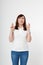 Middle aged woman crossing her fingers and wishing for good luck. Blank white t-shirt, mock up. Fashion outfit with tshirt
