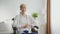 Middle aged woman with disability sitting in wheelchair and smiling to camera, posing at home interior, zoom in portrait